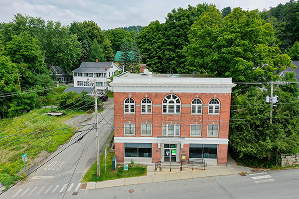 The former Howard / TD Bank building at 424 Main St, Barton Village, Vermont — a three-story brick building with arched windows on Main Street